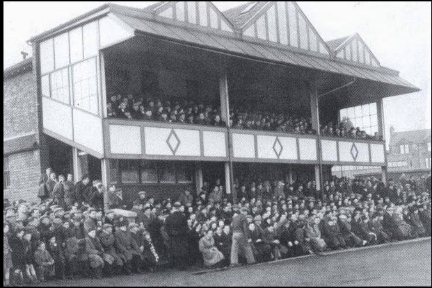 Spectators sitting in and around the pavilion at Airdrie's Broomfield Park